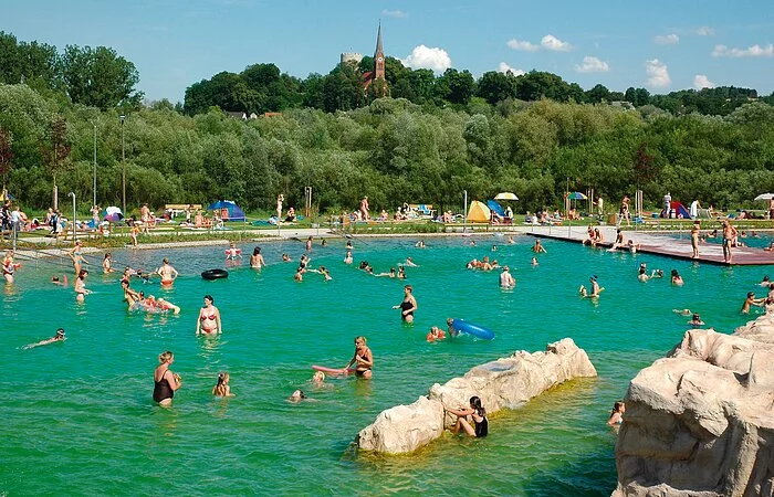 Naturschwimmbad Bad Abbach auf der Freizeitinsel mit Blick auf den Heinrichsturm und die Kirche St. Nikolaus