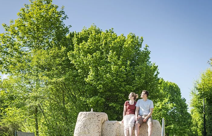 Pärchen sitzend am Wassertretbecken im Kurpark