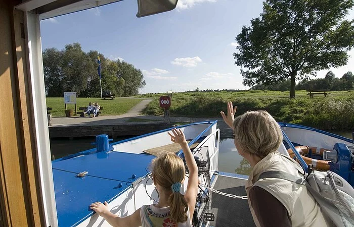 Zwei Passagiere winken ihren Lieben zum Abschied beim Ablegen der MS Altmühlsee