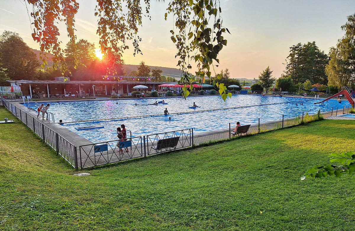 Freibad Thalmässing bei Abendrot Das Freibad ist umgeben von grüner Wiese und Bäumen. Die Sonne ist gerade am Untergehen.
